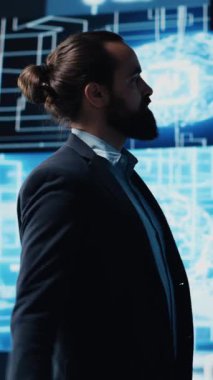 Dikey Video Şirketi lideri, akıllı yenilik ve gelecekteki teknoloji stratejisi için makine öğrenme ve algoritma geliştirme yöntemlerini kullanarak, web platformlarını sembolize eden dijital bir yapay zeka beyniyle etkileşim halindedir.
