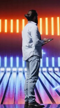 Parlayan neon ışıkların altında parlak renkler ve fütüristik bir atmosferle çevrili dikey Video Cool kişi duruyor. Bir gece sahnesinde bireysellik, kentsel tarz ve yaratıcı tutum