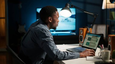 Uzaktan çalışan, proje verilerini düzenleyen, el yazısıyla yazdığı notları inceleyen, internette araştırma yapan biri. Serbest çalışan siyahi kişi serbest işini ve evdeki günlük programını yönetiyor. Kamera B.