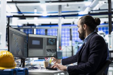 Güneş paneli fabrikasında çalışan erkek üretici rutin bir teftiş yapar, yenilenebilir enerji gelişimine katkıda bulunur ve mühendislik süreçlerinde yüksek standartları sürdürür.