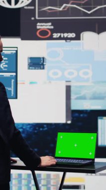 Dikey Video İşadamı, yıllık trendler için telefonda yeşil ekrana bakıyor ve şirket başarısı için bir strateji planlıyor. Aktiviteyi geliştirmek için raporlar ve infografik performans ölçümleri analiz ediliyor