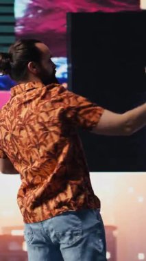 Dikey Video Havalı adam akıllı telefonunu neon ışıkları altında kullanarak içerik yaratıcısı ve DJ olarak fotoğraf ve videoları yakalıyor. Modern tasasız insan gece hayatı sahnesinde görsel sanattan hoşlanır. Kamera B