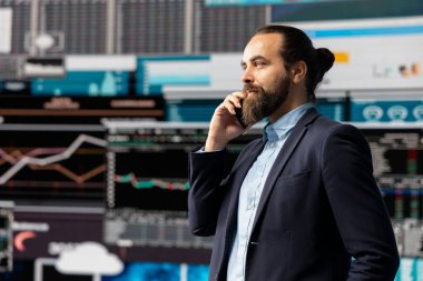 Profesyonel işadamı, şirketin performansını ve sezgilerini değerlendirmek için KPI metrikleriyle çevrili bir telefona cevap veriyor. İşini geliştirmek için uzaktan iletişimi kullanıyor..