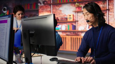 Çağrı Merkezi kıdemli ajanı, müşterilere AI 'ı kullanmaları için adım adım rehberlik ediyor. PC masasındaki müşteri merkezi çalışanı müşterileri yapay zeka kullanarak teknik çözümler üzerinden yürütüyor.