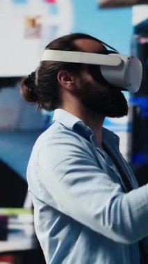 Dikey Video Yüksek Teknoloji uzmanı sanal gerçeklik kulaklığını sosyal medya bağlantısı için suni zekayı gösteren 3 boyutlu bir web tasarımı için kullanıyor. Dijital dünya için hikaye anlatma üzerinde çalışan bir etken