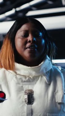 Uzay gemisi kontrol bölümündeki astronot giysisi miğferi ve dizüstü bilgisayarında kırmızı ışığın yanıp söndüğü dikey video. Uzayda dizüstü bilgisayarın yanında hasarlı kozmonot ekipmanı göstergesi uyarısı