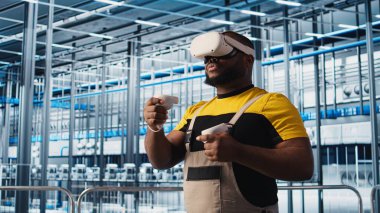 Akıllı fabrika mühendisi, robotik silah ve taşıma bantlarını denetlemek için VR kulaklık kullanıyor. Sanayi 4.0 bitki teknisyeni sanal gerçeklik kullanarak sistem performansını gözlemliyor, kamera A