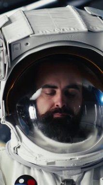 Yabancı gezegendeki yüzey görevini tamamladıktan sonra uzay istasyonunda miğfer tutan mutlu astronotun dikey video portresi. Neşeli kozmonot Dünya 'ya dönmeye hazırlanıyor, kamera B