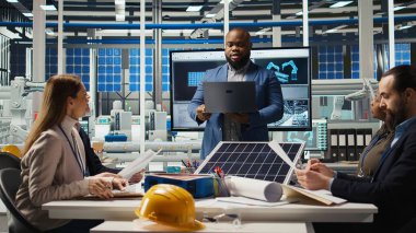 Hissedarlar belgeleri okuyor, temiz enerji üretiminde yatırım fırsatlarını tartışıyorlar. Güneş paneli yöneticileri güneş teknolojisi evrak raporlarını, kamera A 'yı inceliyor.