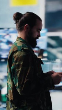 Dijital teknoloji ve uydu verileriyle sanal bir savaş bölgesinde çalışan dikey video ordu subayı, tehdit algılama araçlarını ulusal güvenlik için kullanıyor. Kontrolü sağlamak için modern askeri strateji