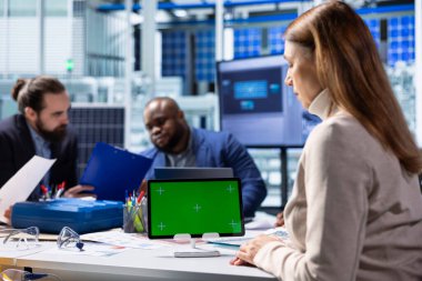 Güneş panelleri enerji sistemlerini incelemek ve teknolojileri geliştirmek için izole ekran tableti kullanan bitki uzmanları kullanıyor. Fotovoltaik fabrikası araştırmacıları verimliliği arttırmak ve kapatmak için model cihazı üzerinde çalışıyorlar.