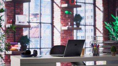 Modern minimalist tasarımı olan lüks bir çatı katında boş bir masa. Parlak, ferah ev ofisi parlak mobilyalar, panoramik pencereler ve yaratıcılık için mükemmel bir ortam içeriyor..