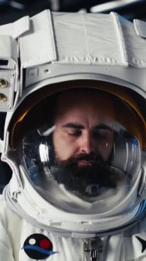 Uzay giysisi içindeki dikey video kadın astronot uzayda insan genleşmesi yapan uzay aracının içindeki bilek cihazını kontrol ediyor. Yıldız gemisi mürettebatı, insanoğlunun uzun vadede hayatta kalmasını destekleyen operasyonlara hazırlanıyor.