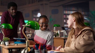 Bayan öğrenci kütüphanede eğitim araştırmaları koleksiyonunu inceliyor, lisans diplomasını almak için sınavlarına çalışıyor. Genç öğrenci burs için savaşıyor. Kamera A.