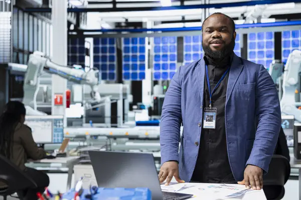 Bir güneş paneli fabrikasında çalışan siyah sanayi mühendisi sistem performansını değerlendiriyor ve verimlilik ve işyeri güvenliğinin izlenmesinde önemli bir rol oynuyor. Fotovoltaikle yenilenebilir güç.