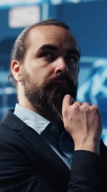 Dikey Video Genç işadamı, programlama, analiz ve stratejik gelişim için yüksek teknolojili otomasyon araçları kullanarak, torpido gözündeki yapay zeka sinir ağlarını inceliyor.