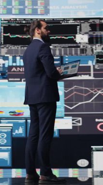 Fintech verileri ve tahmin modelleriyle çevrili dikey video, raporları analiz eden yetenekli girişimci ve ticari büyümeyi yönlendiren içgörü. Şirket verimliliği ve akıllıca kararlar verme. Kamera B.