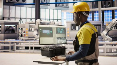 PC yazılımını kullanarak güneş paneli üretim ekipmanlarını denetleyen mühendis. Otomatik sanayi 4.0 fabrikasında bilgisayar, kamera A kullanarak fotovoltaik montaj sistemleri sürdüren işçiler