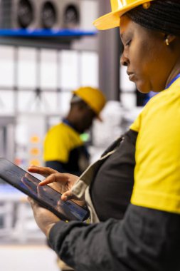 Endüstriyel otomasyonu programlamak ve modernize etmek için tablet kullanan mühendislerin kapatılması, sanayi 4.0 tesisinde üretim verimliliğini güvence altına alıyor. Kadın teknisyen otomatik makine geliştiriyor..