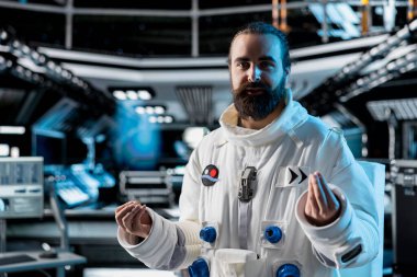 Astronot, Dünya 'daki komuta merkeziyle video görüşmesi sırasında Yıldız Gemisi' nde açıklama yapıyor. Yörünge istasyonu mürettebatı yer kontrol bağlantısıyla iletişim sırasında görev güncellemesi yapan araştırmacılarla konuşur.