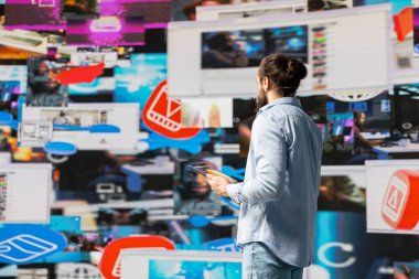 Elleri boş mikrofonla, canlı bir tartışma sunumuna ev sahipliği yapan erkek nüfuzlu kişi görünürlük kavrayışı sağlıyor. Erkek konuşmacı seyircilere çevrimiçi bağlılığı artırmaları yönünde tavsiyede bulunuyor.