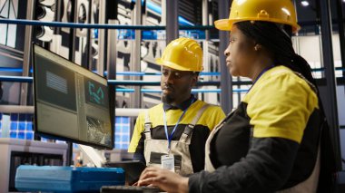 Endüstriyel fabrikadaki yönetici denetleme teknisyeni arızaları teşhis etmek için bilgisayar yazılımı kullanıyor. Fabrika ekip lideri, montaj hatlarındaki tamir görevlerini koordine etmek için iş arkadaşıyla birlikte çalışıyor. Kamera A