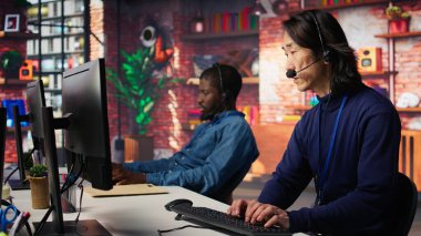 Çağrı Merkezi kıdemli ajanı mutsuz müşterilerle ilgileniyor, sorunları dinliyor. Deneyimli Asyalı müşteri hizmetleri çalışanı şirket çalışma alanı, kamera B 'de şikayette bulunuyor.