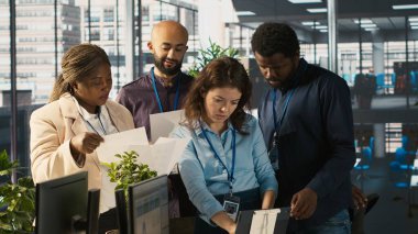 Görevdeki gülümseyen işçilerin portresi son teslim tarihinden önce projeyi bitirmek için birlikte çalışıyorlar, beyin fırtınası yapıyorlar. Memurlardan oluşan bir ekip görevlerde işbirliği yapıyor, belgeleri çapraz inceliyor, kamera A