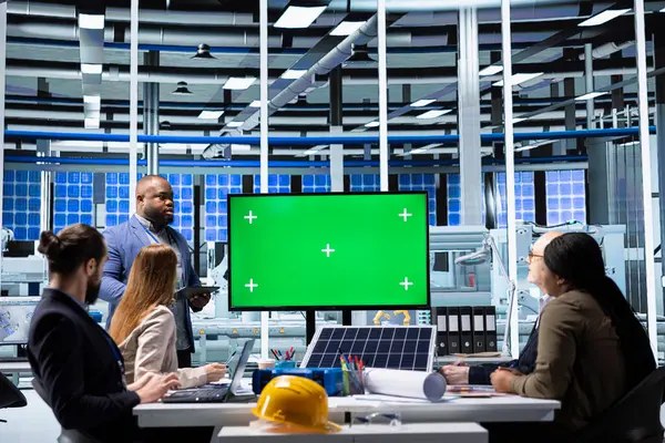 Güneş panelleri fabrika yöneticisi, imalat stratejilerini yatırımcılara sunmak için yeşil ekran monitörü kullanır. Fotovoltaics fabrika yöneticisi hissedarlara veri göstermek için model ekran kullanıyor