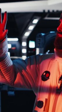 Tebessüm eden astronotun koruma kaskı tutarken uzayda insan büyümesi yaptığı dikey video portresi. Yıldız gemisindeki neşeli adam uzun vadede insanlığı destekleyen keşif gezisine hazırlanıyor, kamera B