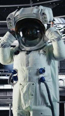 Yüksek teknolojili uzay aracının içindeki gülümseyen astronotun dikey video görüntüsü rutin görev kontrolü sırasında ekipman çantasını tutuyor. Mars verilerini gösteren mutlu bir yıldız gemisi mürettebatı ekranın yanında duruyor.