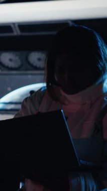 Dikey video astronot Mars yolculuğu sırasında tablet üzerindeki uzay görevi verilerini kontrol ediyor. Yıldız gemisindeki kozmonot, uzun vadede insanlığı destekleyen Kızıl Gezegen gezisine hazırlanıyor.