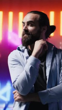 Dikey Video Tarzı genç bir adam sanal gerçeklik kulaklığı kullanarak sanatsal titreşimleri yansıtıyor, eğlencenin esinlendiği siber bir atmosferde renkli neon ışıklarla çevrili. Gece hayatı minimalizmi