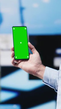 Dikey Video Gündelik stil adamı akıllı telefonuyla yeşil ekran arkaplanını tarıyor, sosyal ağ platformlarına bağlanıyor ya da mesajlaşıyor. Genç yetişkin sosyal medya uygulamalarına odaklandı