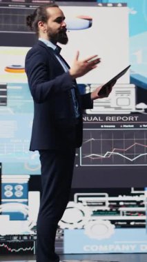 Dikey Video Motivasyon Konuşmacısı ve iş adamı katılımcı kalabalığa konuşma sunuyor. Uzman, görünür mali tablolarıyla yatırım, iş planlaması ve girişimciliği kapsıyor