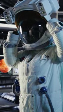 Yabancı gezegendeki yüzey görevini tamamladıktan sonra uzay istasyonunda miğfer tutan mutlu astronotun dikey video portresi. Neşeli kozmonot Dünya 'ya dönmeye hazırlanıyor. Kamera A.