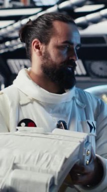 Uzay gemisinde tablet kullanan dikey video kozmonot insanoğlunun hayatta kalma seferi sırasında güvenlik kontrolü yapıyor. Astronotlar uzay görevinde insan genleşmesi sırasında yaşam destek sistemlerini izliyorlar