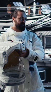 Kozmonot uzayın derinliklerinden yaklaşan bilinmeyen bir uzay aracını izlerken parlayan dikey video uzay gemisi kokpiti. İnsan, yörünge istasyonu yakınlarında gezinen dünya dışı varlığa tepki veriyor. Kamera A.