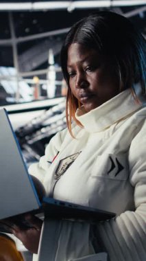 Dikey video, kadın astronot gözleri yabancı gemi ışığından koruyor. Uzay istasyonundaki dikkatli Afrikalı Amerikalı kadın dünya dışı varlıkla ilk teması bekliyor, kamera A