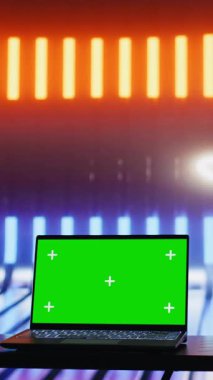 Renkli neon ışıkları ve izole edilmiş bir dizüstü bilgisayarı olan dikey video boşluğu fütüristik siber punk titreşimi ve sanatsal görsel tasarım yaratır. Parlak renklerle modern şehir tarzı. Kamera B.