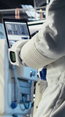 Dikey video astronot Mars yolculuğu sırasında tablet üzerindeki uzay görevi verilerini kontrol ediyor. Yıldız gemisindeki kozmonot, uzun vadede insanlığı destekleyen Kızıl Gezegen gezisine hazırlanıyor.