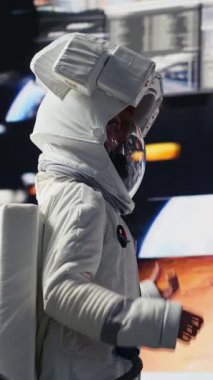 Uzak bir gezegende uzay giysisi ve miğferiyle dikey video meraklısı astronot gökyüzünün altında yıldızlarla dolu örnekler topluyor. Bir uzayda yabancı dünyaları ve kozmik sınırları keşfetmek.