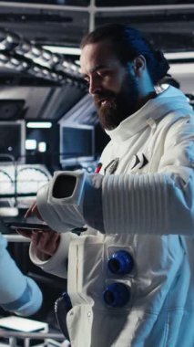 İleri teknoloji uzay aracındaki astronotlardan oluşan dikey video ekibi rutin görev kontrolü sırasında Kırmızı Gezegen Özet Analizlerini kontrol ediyor. Takım çalışması Yörünge İstasyonu mürettebatı incelemek için aygıt kullanıyor