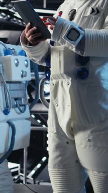 Uzay gemisinde derin uzayı keşfederken miğfer takan neşeli astronotların dikey video görüntüsü. Uzay gemisinden ayrıldıktan sonra yörüngedeki kozmonot yolculuğun kutlu olsun.