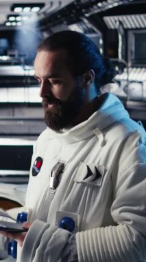 Uzay istasyonu dışında planlanan operasyonlara katılmadan önce güvenlik kontrolü yapan dikey video astronotu. Kozmonot cihazdaki dişli kontrollerini kontrol eder, indikten sonra ayrılmaya hazırlanır.