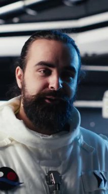 Uzay gemisinin derinliklerinde keşif yapan kasklı neşeli astronotların dikey video portresi. Neşeli Kozmonot Gezegen B 'den ayrıldıktan sonra uzay aracının gövdesini inceliyor.