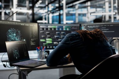 Bitkin sunucu mühendisi ekipman arızasını azaltmak için veri analiz grafiğine bakarken uykuya dalıyor. Bütün gün yapay zeka gösterge paneline baktıktan sonra yorgun veri merkezi çalışanı yoruldu.