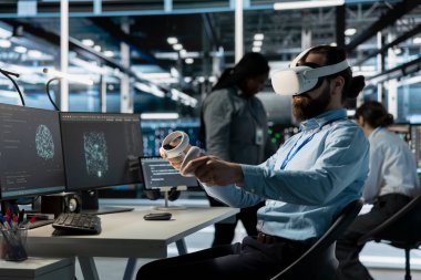 VR kulaklık teknolojisi kullanan yazılım geliştiricisi, veri yoğunlaştırılmış işlemleri yapan sunucu dolaplarını denetliyor. Süper bilgisayarları denetlemek için sanal gerçeklik ekipmanı kullanan bilişim uzmanı