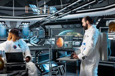 Kozmonot, Mars seferinden önce veri analizi yaparak insanlığın geleceğine hazırlanıyor. Astronot yörünge yolunu gösteren arayüze bakıyor, insan yaşamını desteklemek için kızıl gezegeni keşfediyor.