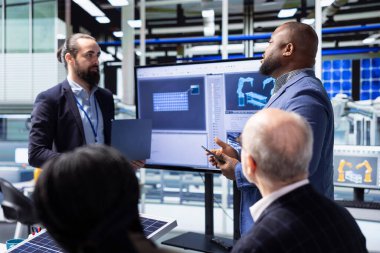 Yatırımcı fotovoltaik fabrikasındaki yatırım toplantısında fabrika yönetimine hitaben, robotik, otomasyon süreçleri ve stratejik büyüme olanaklarını tartışıyor